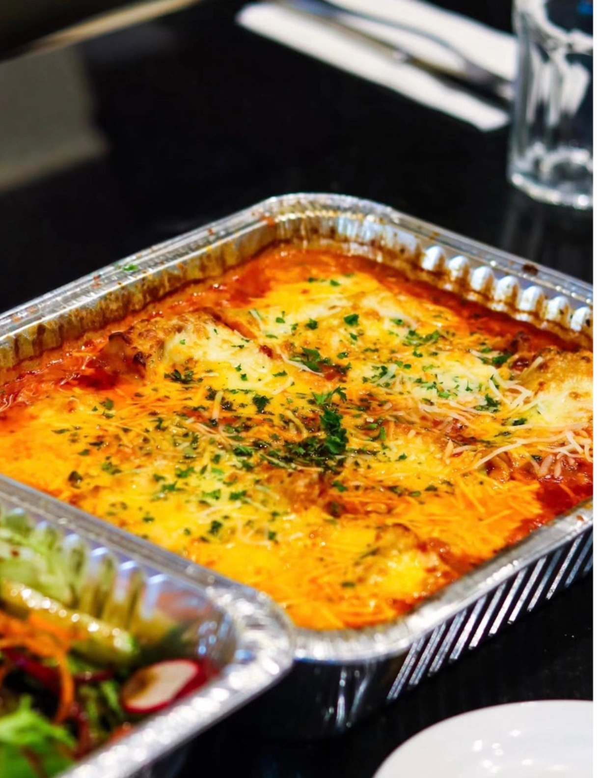 pasta page in sauce and fully topped with lots of cheese